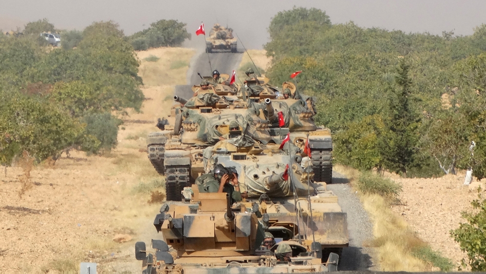Turkish army tanks make their way towards the Syrian border town of Jarablus