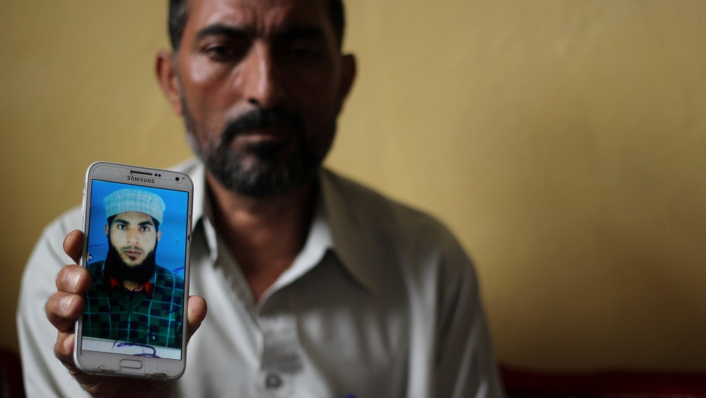 Abdul Rehman Mir with the only photo he has of his son Shabir, who was killed by police in Tengpora, Srinagar on July 10 [Aarabu Ahmad Sultan/Al Jazeera]