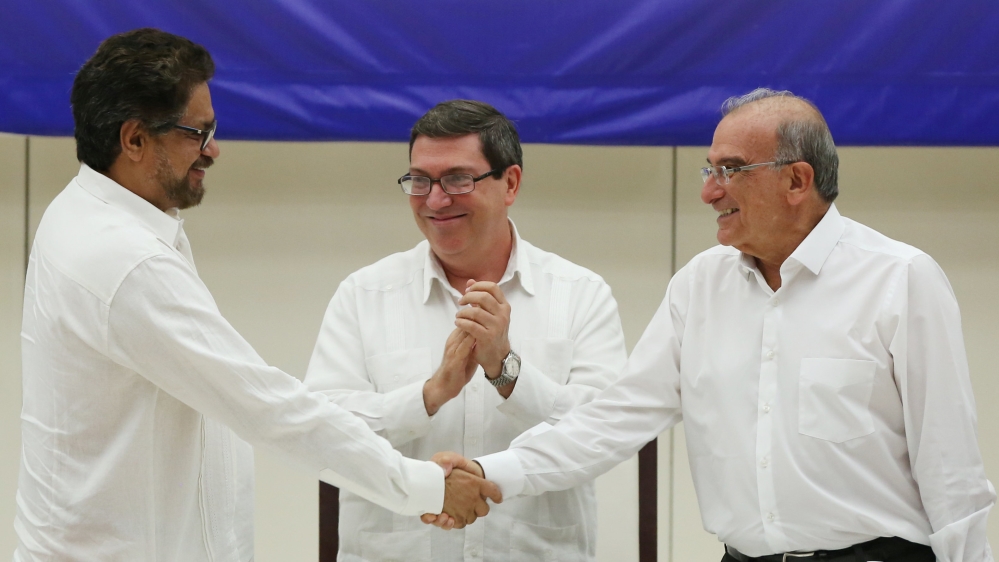 Colombia''s FARC lead negotiator Ivan Marquez and Colombia''s lead government negotiator Humberto de la Calle shake hands while Cuba''s Foreign Minister Bruno Rodriguez looks on, after signing a final p