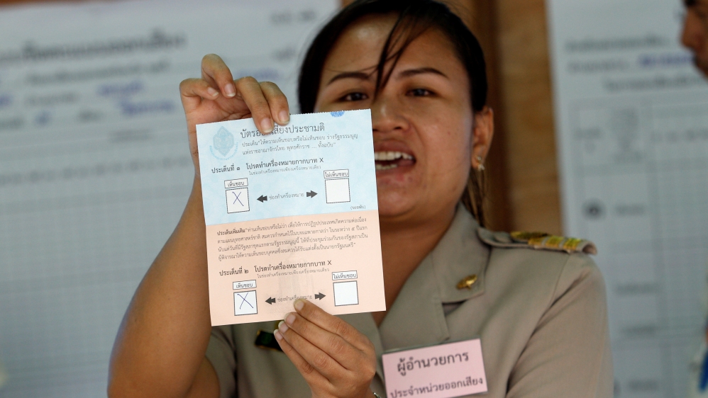 A Thai electoral worker starts counting ballots at a polling station during a constitutional referendum vote in Bangkok