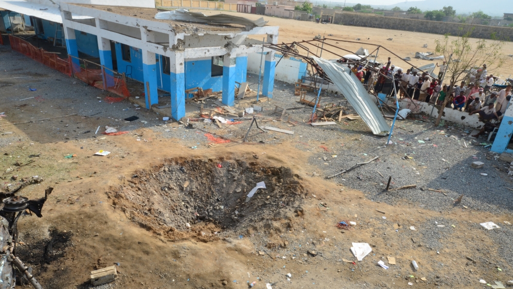 People look at a crater caused by a Saudi-led coalition air strike at the yard of a hospital operated by Medecins Sans Frontieres in the Abs district of Hajja province, Yemen