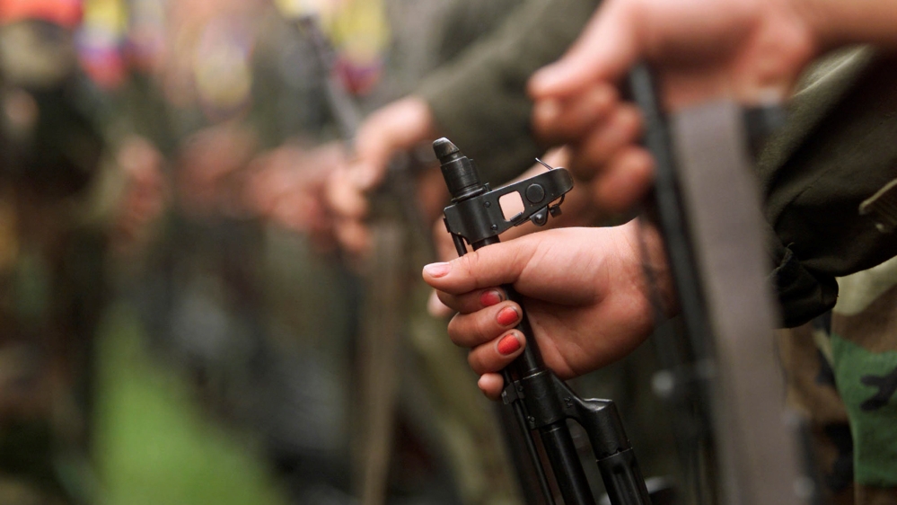 A Colombian guerilla woman holds her gun as she takes part in a line of rebels during an army parade of fighters of the FARC in Villa Colombia camp near San Vicente del Caguan