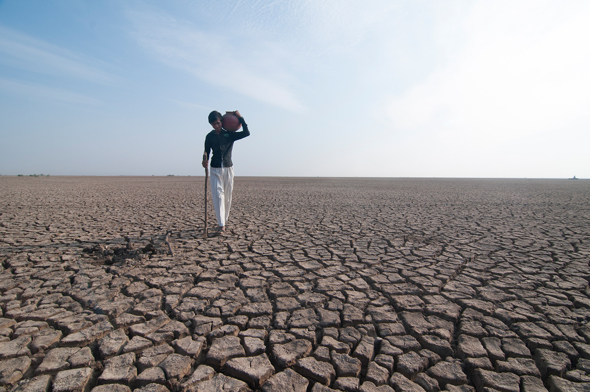 Chhotu, 15, brings water to his family. Rann of Kutch has a scarce supply of drinking water and he must walk 6km to reach the supply. The low income level and lack of education facilities in the barre