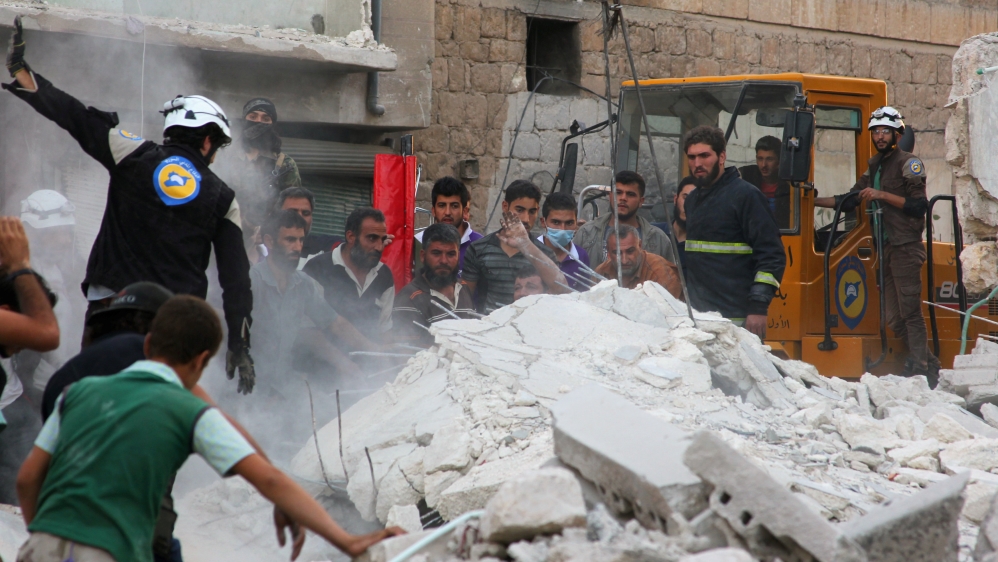 Civil defence members and civilians search for survivors under the rubble of a damaged site hit by airstrikes in Idlib