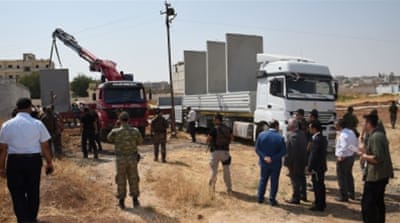 Civil and military authorities inspect the construction of a border wall between Turkey and Syria near the border gate in Suruc [Reuters]