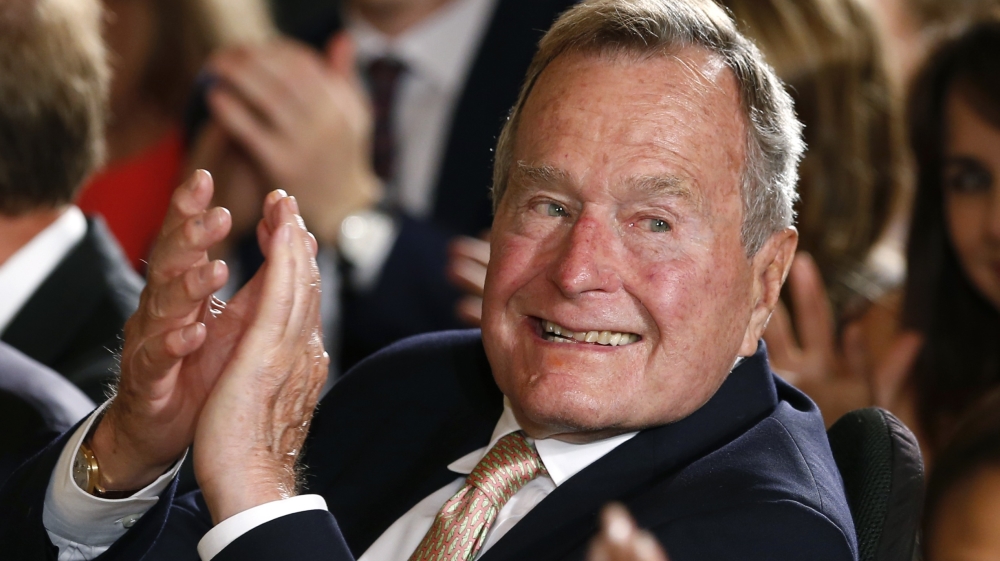 Former President George H. W. Bush applauds during an event to honor the winner of the 5,000th Daily Point of Light Award at the White House in Washington