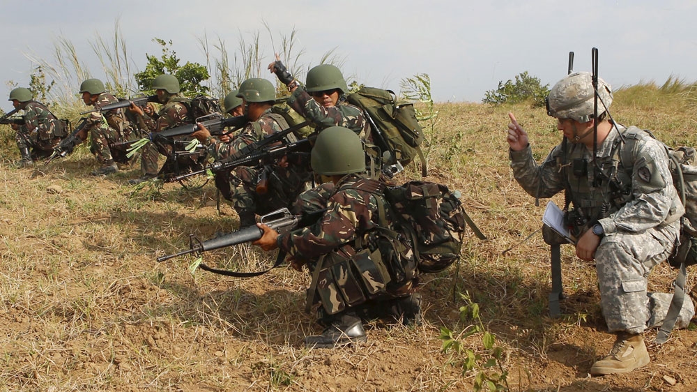 A US soldier gives instruction to his Filipino counterpart during a 2015 joint 'war games' at a military camp in northern Philippines [Reuters]