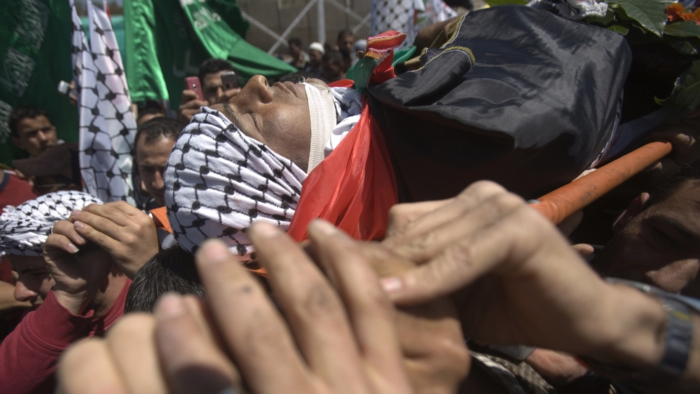Palestinians carry the body of Bassem Ibrahim Abu Rahmah during his funeral in the West Bank village of Bilin [Fadi Arouri/Reuters]