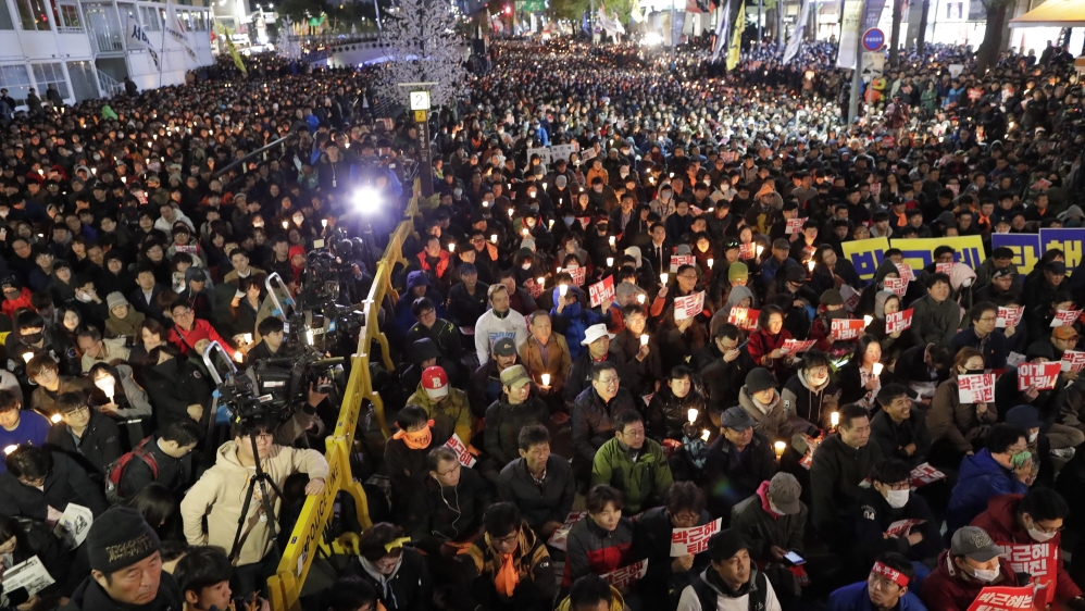 South Korean protesters shout slogans with candlelight during a protest against South Korean President Park Geun-hye on the main street in Seoul [EPA]