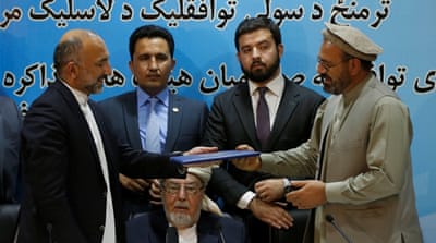 Mohammad Amin Karim, right, and Afghanistan national security adviser Mohammad Hanif Atmar, left, hold a document after signing a peace deal in Kabul September 22, 2016 [Omar Sobhani/Reuters]