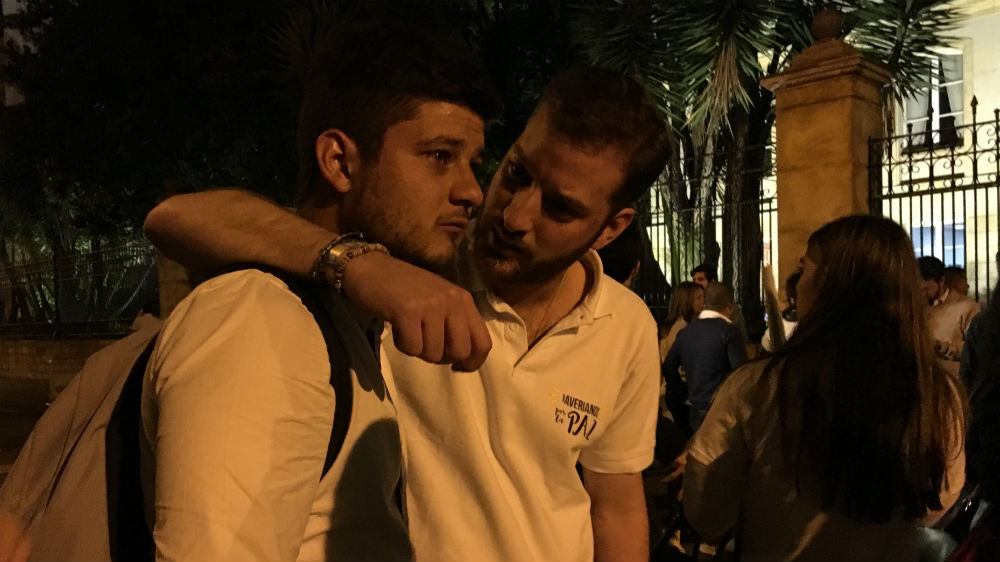 Mario Carvajal, right, comforts his friend Juan Jose [Anne Bouleanu/Al Jazeera]