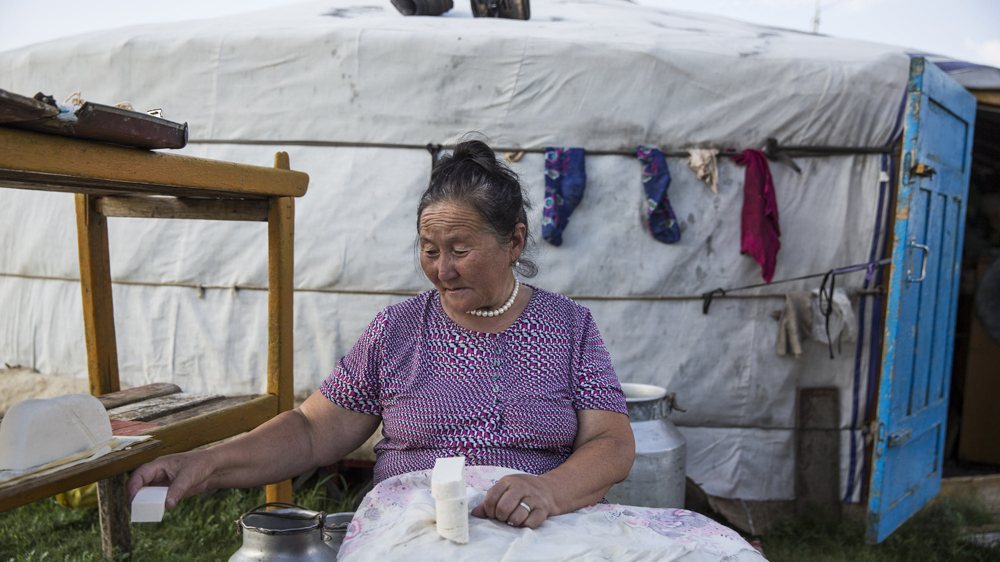 A woman makes dairy products to sell in Ikh Tamir [Taylor Weidman/Al Jazeera]