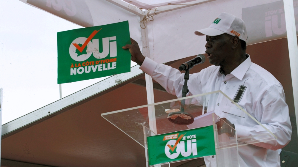 Ivory Coast''s President Alassane Ouattara holds a placard as he speaks during a rally, ahead of the referendum of a new constitution, in Abidjan