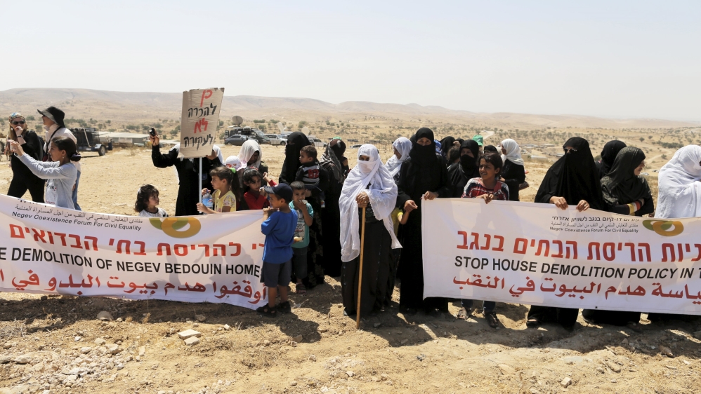 Women, residents of the Umm Al-Hiran, a Bedouin village which is not recognised by the Israeli government, hold banners during a protest in Israel''s southern Negev desert