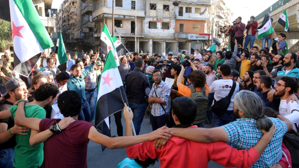 People carry Free Syrian Army flags while attending a protest against evacuating civilians out of Aleppo, in the rebel held besieged al-Shaar neighbourhood of Aleppo