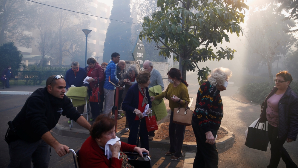 Emergency personnel evacuated elderly people in the northern areas of Haifa [Baz Ratner/Reuters]