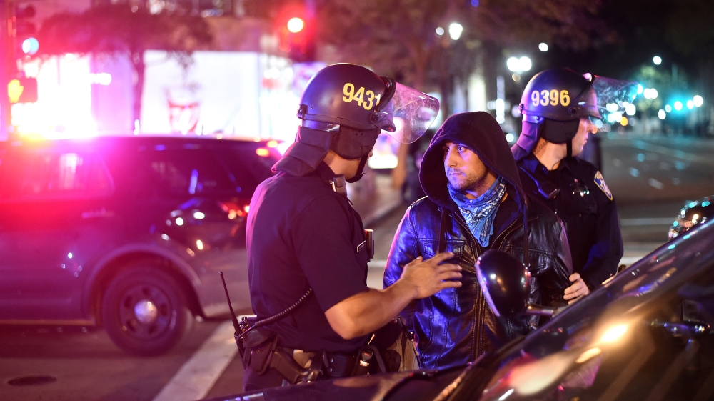 Police detain a protester marching against Trump in Oakland [Noah Berger/Reuters]