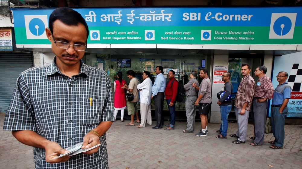 A man counts Indian rupee banknotes after withdrawing them from an ATM in Kolkata [Rupak De Chowdhuri/Reuters]