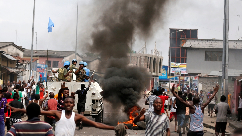 Residents chant slogans against Congolese President Joseph Kabila as peacekeepers MONUSCO patrol during demonstrations in the streets of the DRC capital Kinshasa
