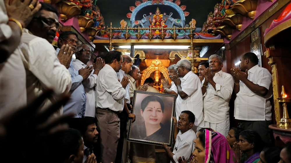 Supporters of Tamil Nadu Chief Minister Jayalalithaa Jayaraman hold her portrait as they pray[Danish Siddiqui/Reuters]