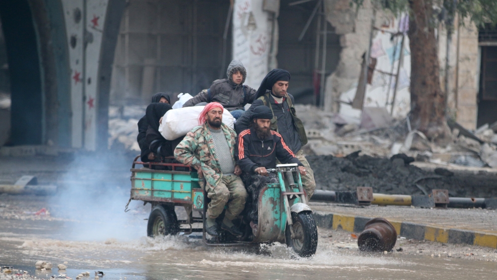People ride a tricycle as they flee deeper into the remaining rebel-held areas of Aleppo