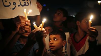Children in Gaza hold banners that read 'save us' [Reuters]