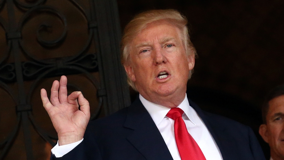 U.S. President-elect Donald Trump talks to members of the media as Retired U.S. Army Lieutenant General Michael Flynn stands next to him at Mar-a-Lago estate in Palm Beach, Florida