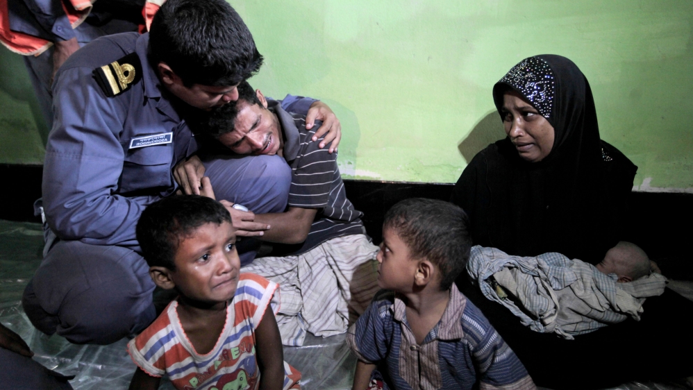 
Mohammad Rafique, a Rohingya Muslim from Myanmar, centre, begs a Bangladesh Coast Guard official not to send his family back to Myanmar at Shahporir Dwip in Taknaf, Bangladesh [AP]
