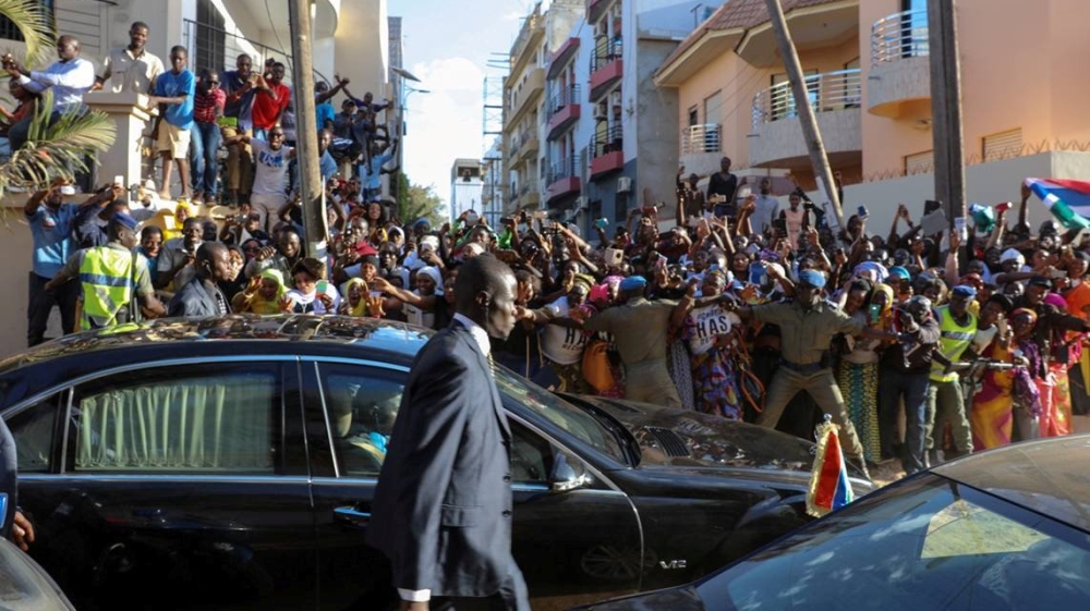 Hundreds of well-wishers cheer and wave as Gambia President Adama Barrow is driven after his inauguration ceremony at the Gambian embassy in Dakar