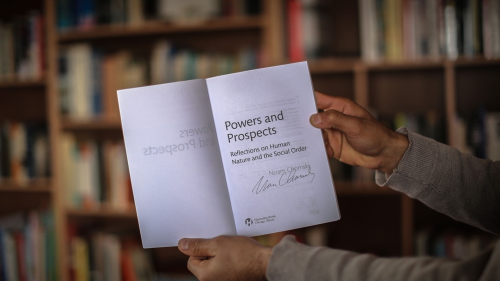 Abu Toha has so far collected more than 100 books, including a few signed volumes by Noam Chomsky [Ezz Zanoun/Al Jazeera]