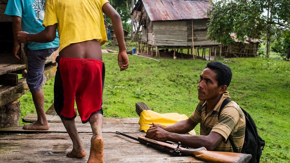 An armed Miskito man takes a break during a patrol in Wiwinak, Nicaragua. The peaceful life in Miskito villages has disappeared since the resumption of violence in 2015 [Alex McDougall/Al Jazeera]