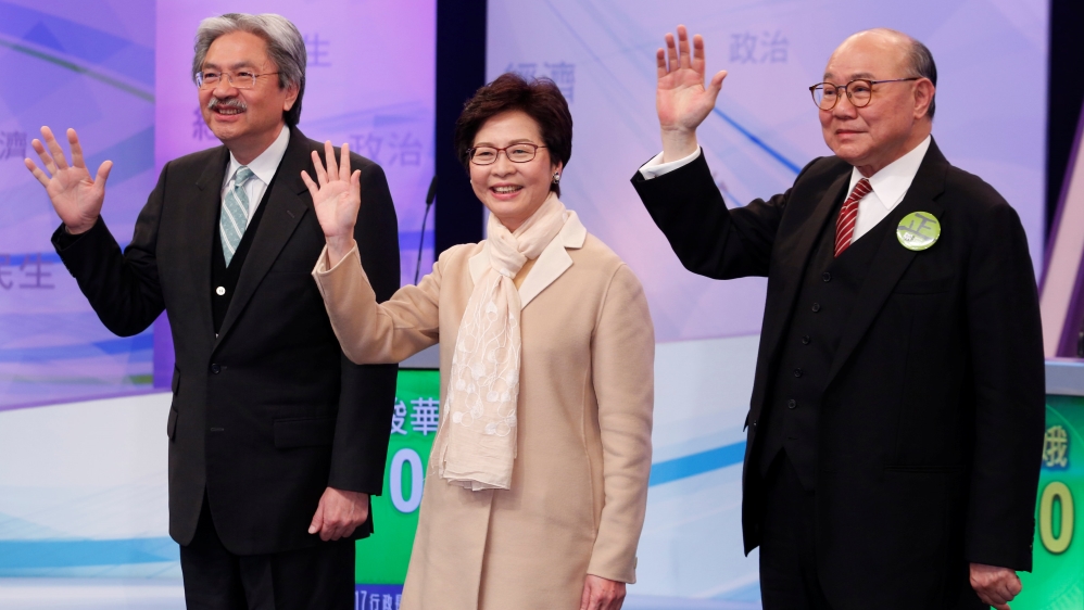 Chief Executive candidates John Tsang, Carrie Lam and Woo Kwok-hing pose before a debate in Hong Kong