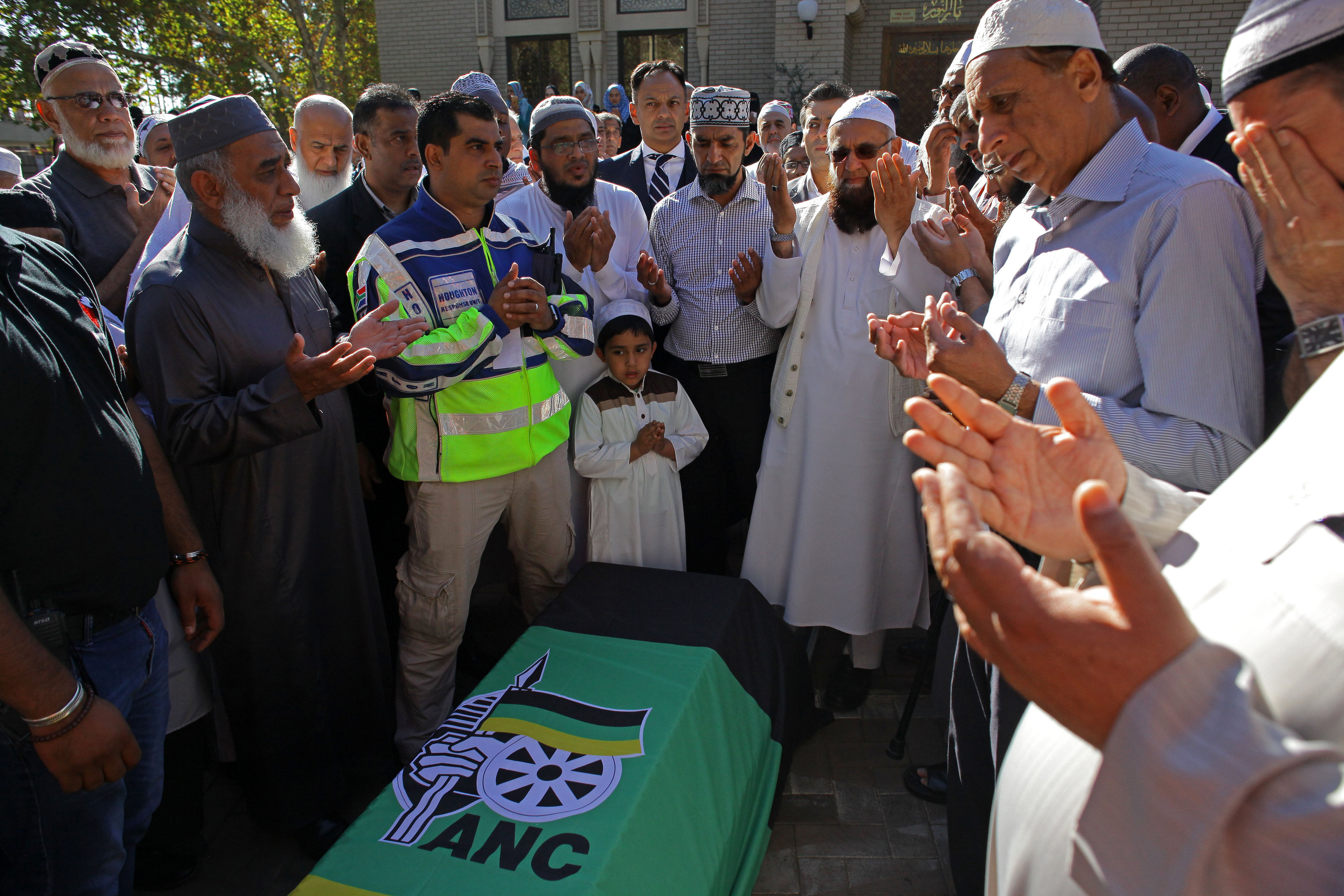 Mourners pray next to the coffin of anti-apartheid activist Ahmed Kathrada [Kevin Sutherland/EPA] 
