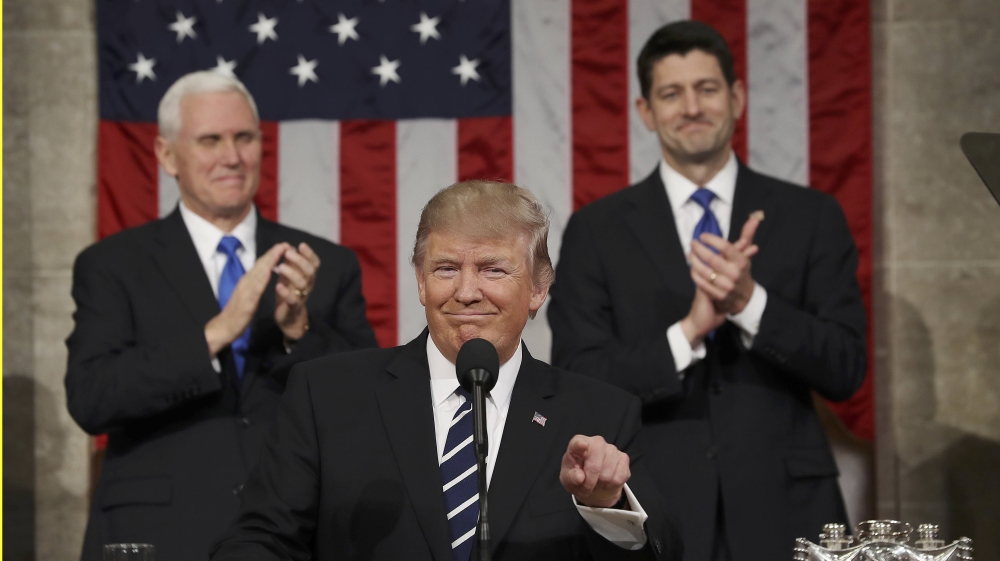 US Vice President Mike Pence, left, and Speaker of the House Paul Ryan applaud Trump at Capitol Hill [Jim Lo Scalzo/Reuters]