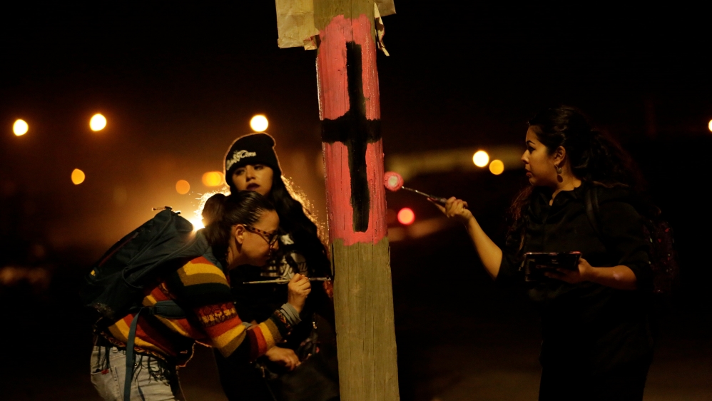 Women in Mexico remember missing or killed women by marking lamp posts with crosses. [Jose Luis Gonzalez/AFP]