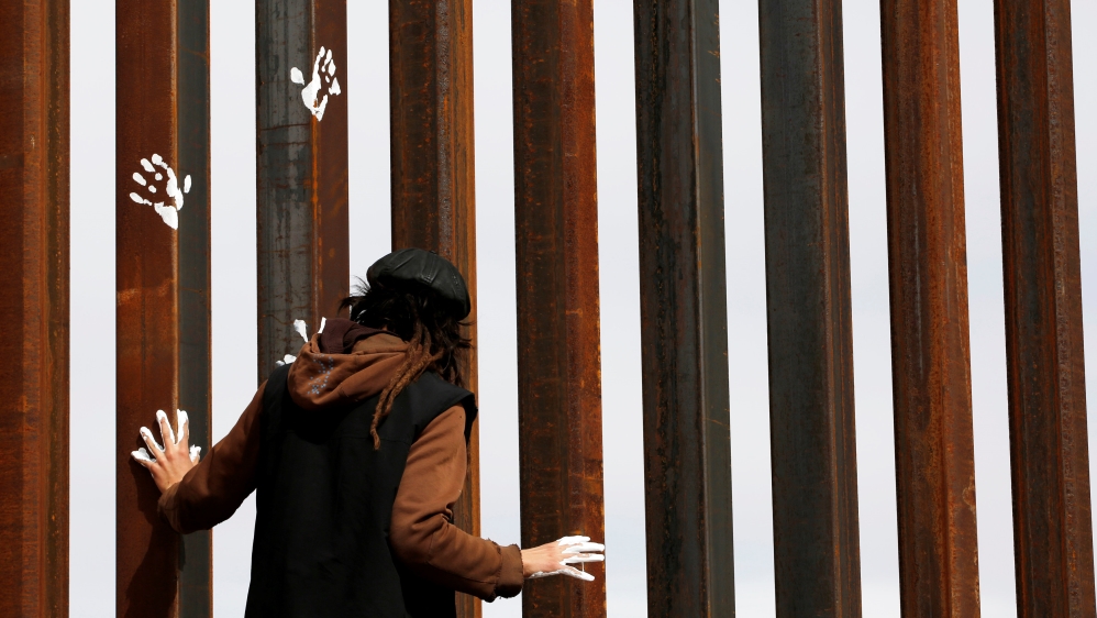 Activist paints the U.S.-Mexico border wall between Ciudad Juarez and New Mexico as a symbol of protest against U.S. President Donald Trump''s new immigration reform in Ciudad Juarez, Mexico