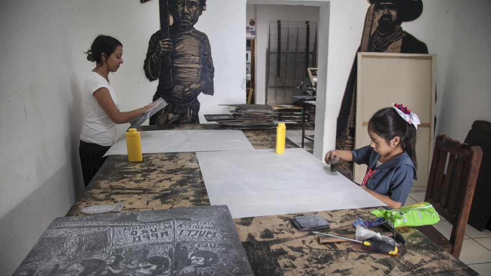 
Friends and family finishing prints at Espacio Zapata [Gabriela Campos/Al Jazeera] 