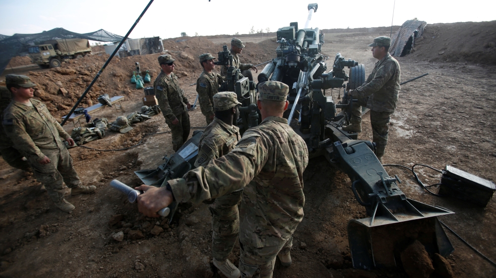U.S. soldiers from the 2nd Brigade, 82nd Airborne Division clean the barrel of the artillery at a military base north of Mosul, Iraq