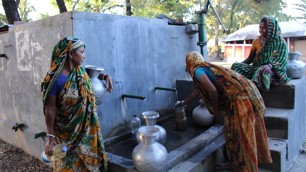 Women gather around the water pump in Fultala. In the rainy season, the line at the pump is shorter as women collect rainwater in plastic drums and pots. [Neha Thirani Bagri/The GroundTruth Project]