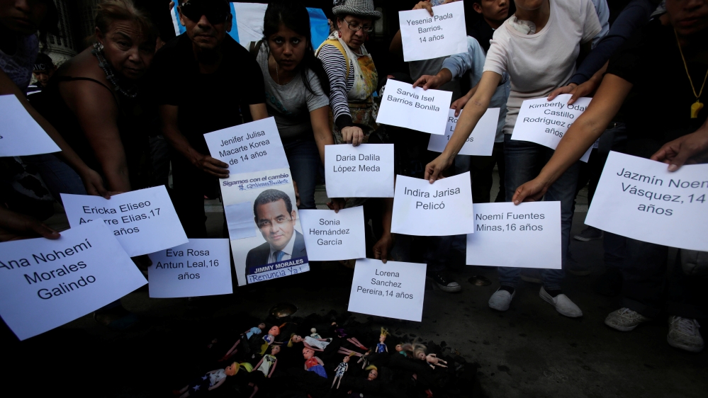 Protesters hold signs with the names of the victims to demand justice in front of the National Palace in Guatemala City [Reuters/Saul Martinez]