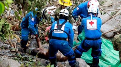 Red Cross staff recover a body after a landslide caused by the overflow of three rivers, in Mocoa, Colombia,[Leonardo Munoz/EPA]