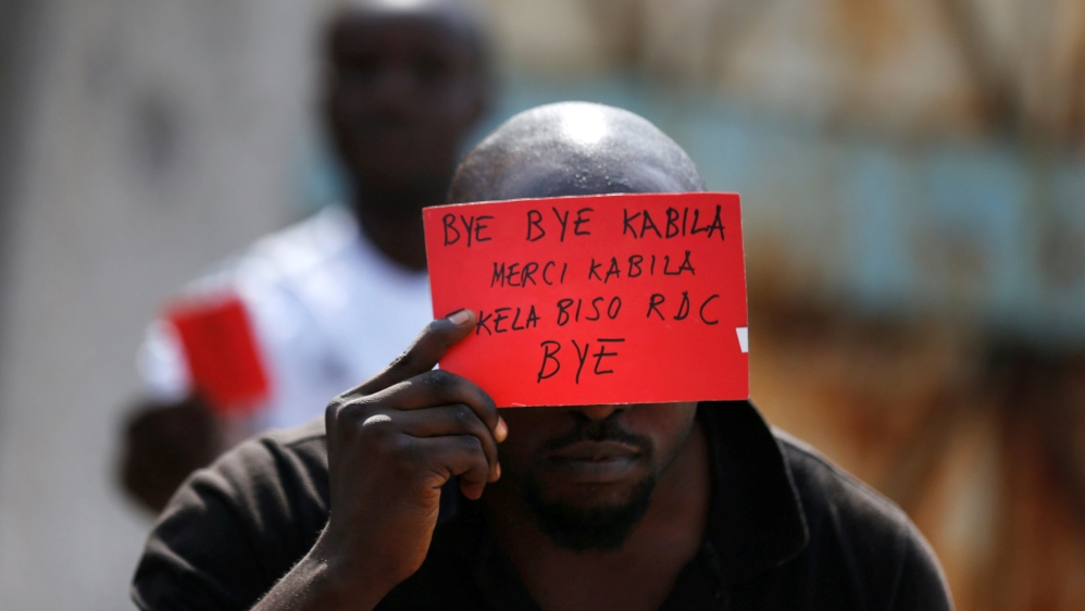 FILE PHOTO: A Congolese opposition party supporter displays a red card against President Joseph Kabila in Kinshasa