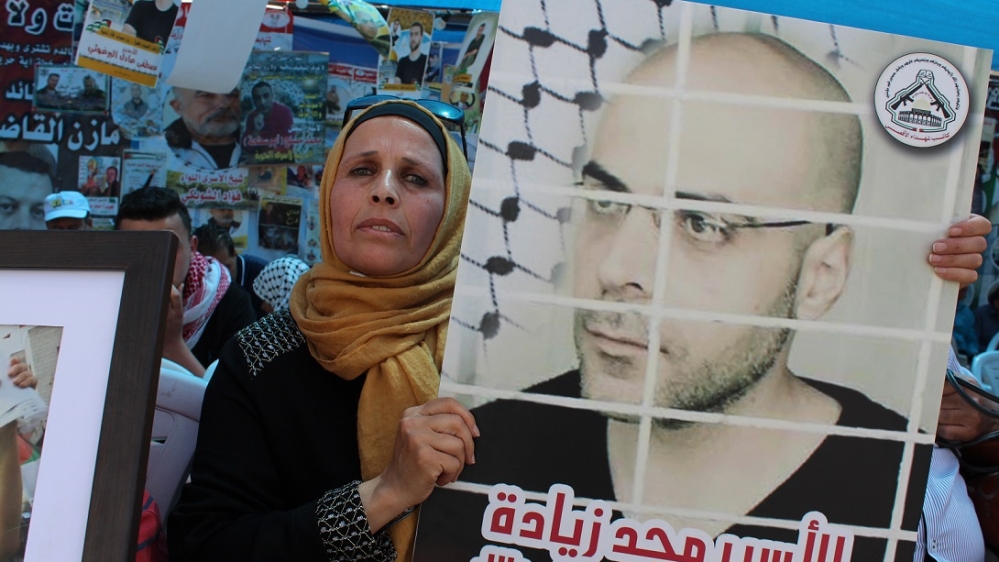 Naema Ziadeh holds another photograph of Majd, who was recently transferred into solitary confinement [Nigel Wilson/Al Jazeera]