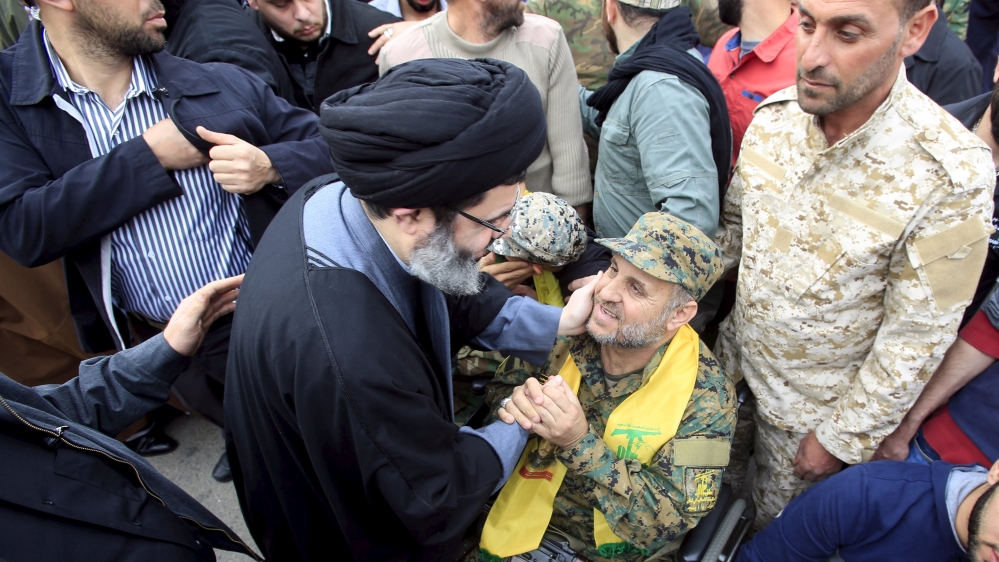 Sayyed Hashem Safieddine, head of the Hezbollah Executive Council, greets a Hezbollah fighter, who was injured fighting in Syria, during the funeral of Ali Fayyad in Ansar village