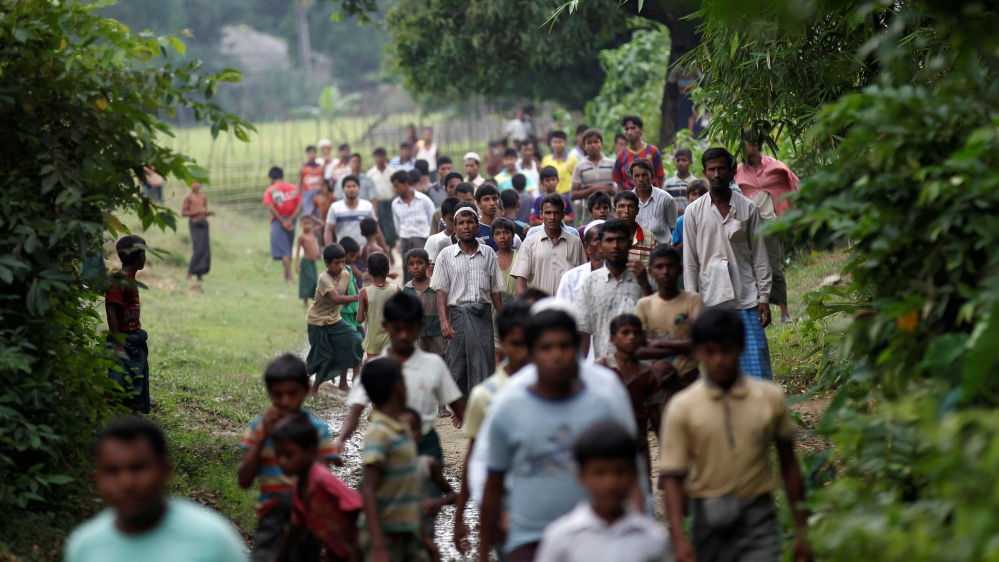 FILE PHOTO: Men walk at a Rohingya village outside Maugndaw in Rakhine state
