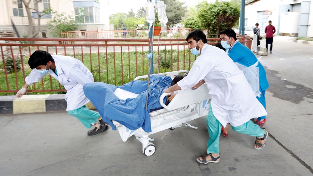 Medical personnel moved the injured to a hospital after the suicide attack in Kabul [Mohammad Ismail/Reuters]