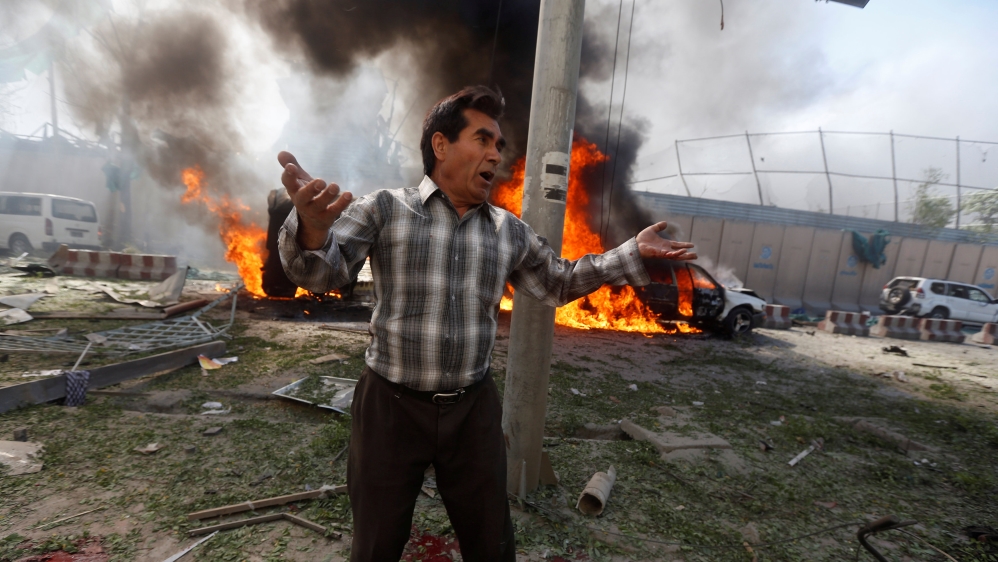 An Afghan man reacts at the site of a blast in Kabul, Afghanistan