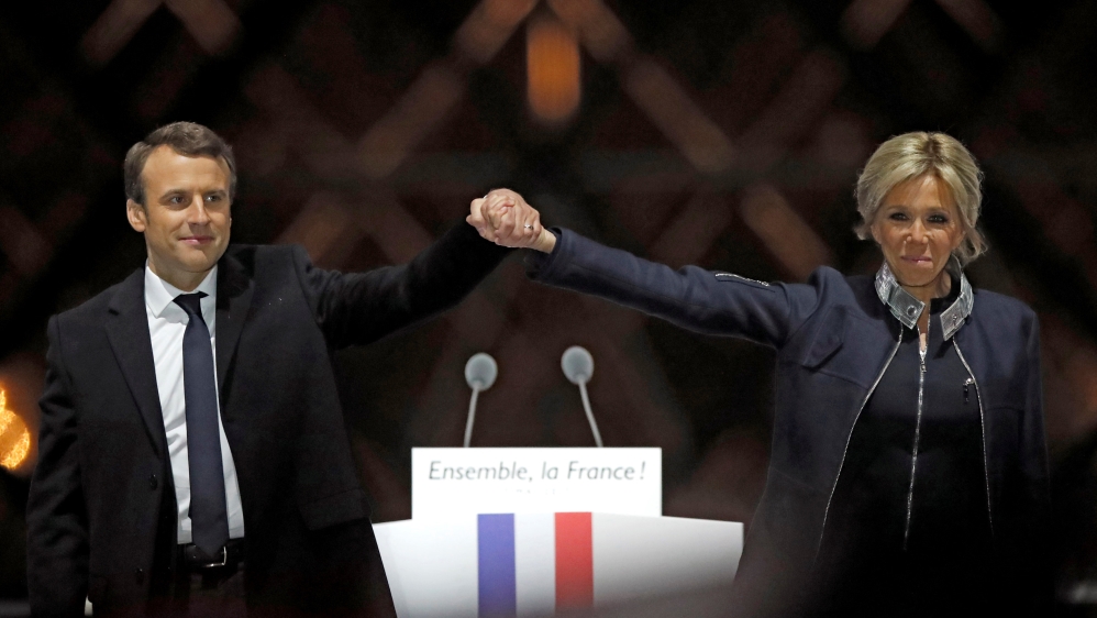 French President elect Emmanuel Macron and his wife Brigitte Trogneux celebrate on the stage at his victory rally near the Louvre in Paris