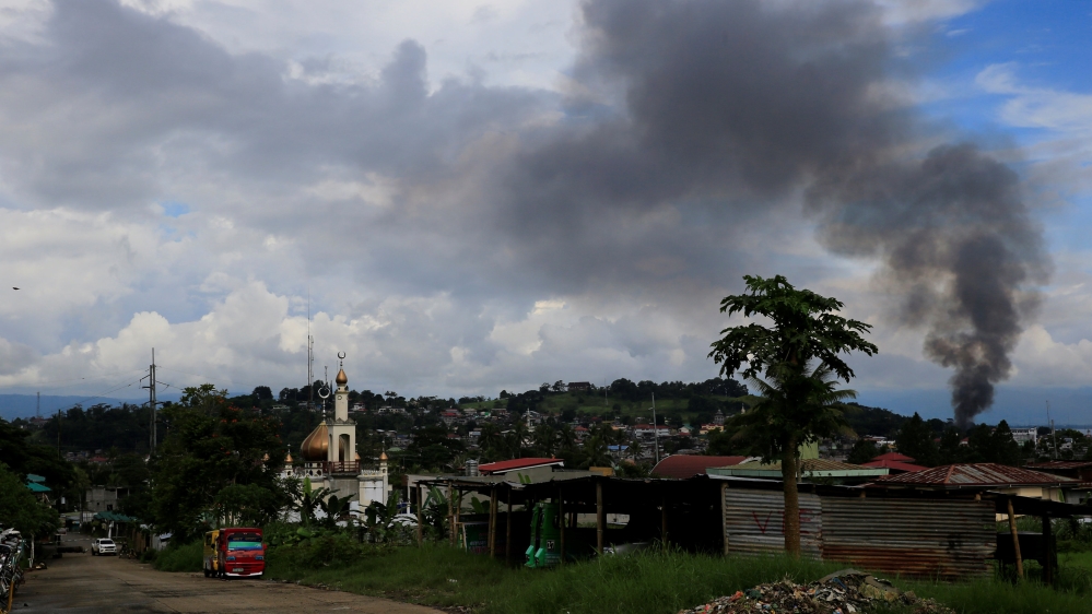 A black smoke comes from a burning building at a Marinaot town, after government troops continuous assault with insurgents from the so-called Maute group, who