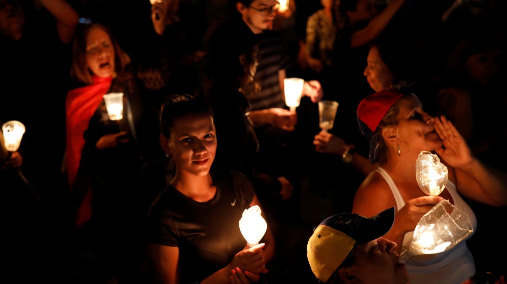 Opposition supporters stage candlelight rally against President Nicolas Maduro in Caracas [Marco Bello/Reuters]